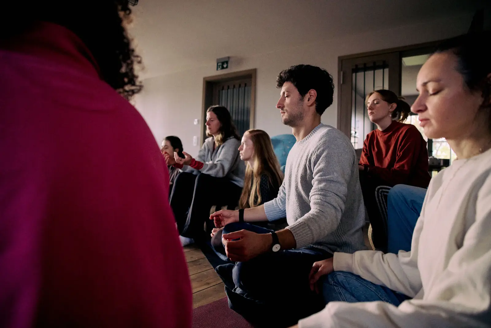 A seated circle with eyes closed during a breathwork session.