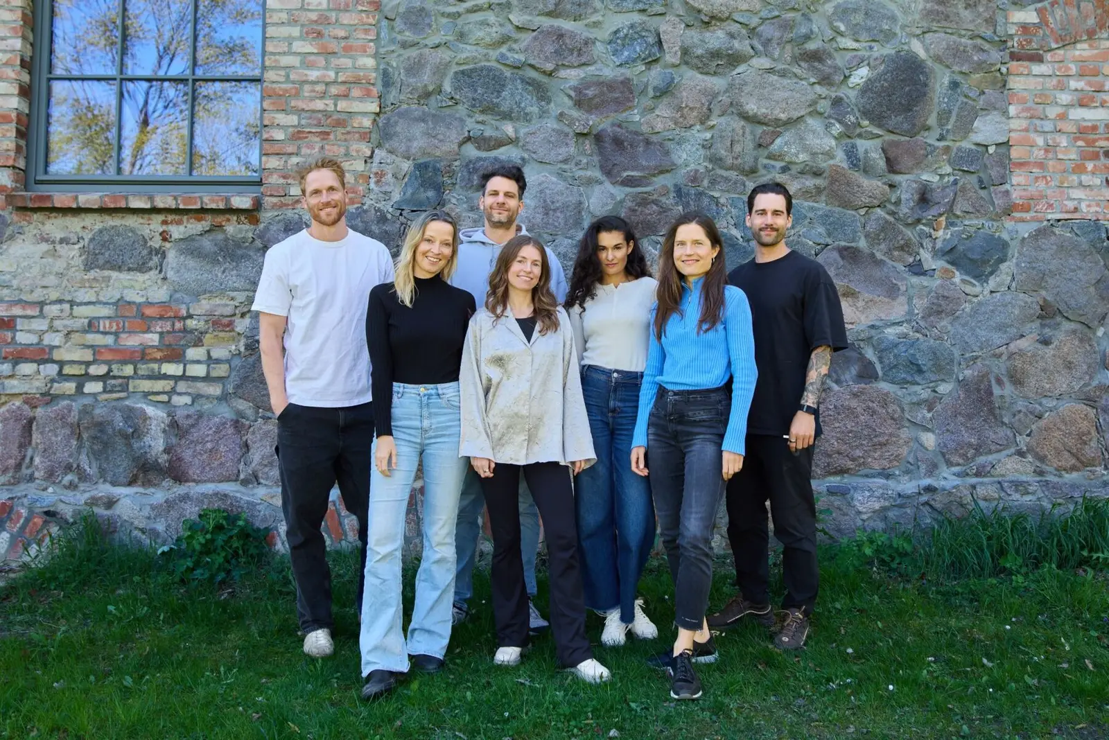 The team behind the programme, standing together outside a stone building.